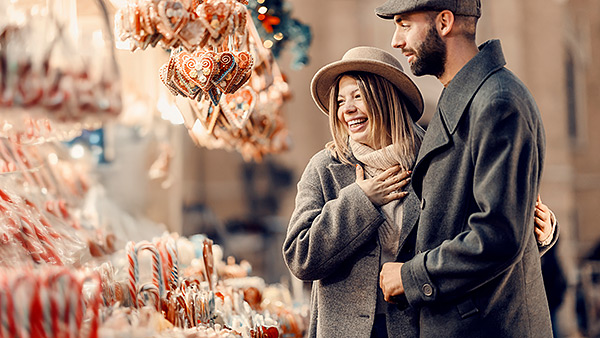 Mann und Frau stehen an Weihnachtsstand.